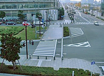 Birds-eye view of a road with clear walkways, expanded corners, safety islands, and bike lanes